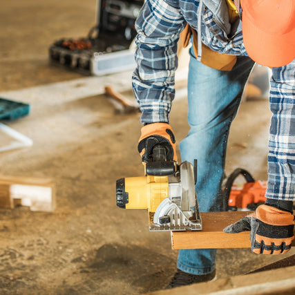 Industrial SuppliesA contractor using a saw to cut a piece of wood.