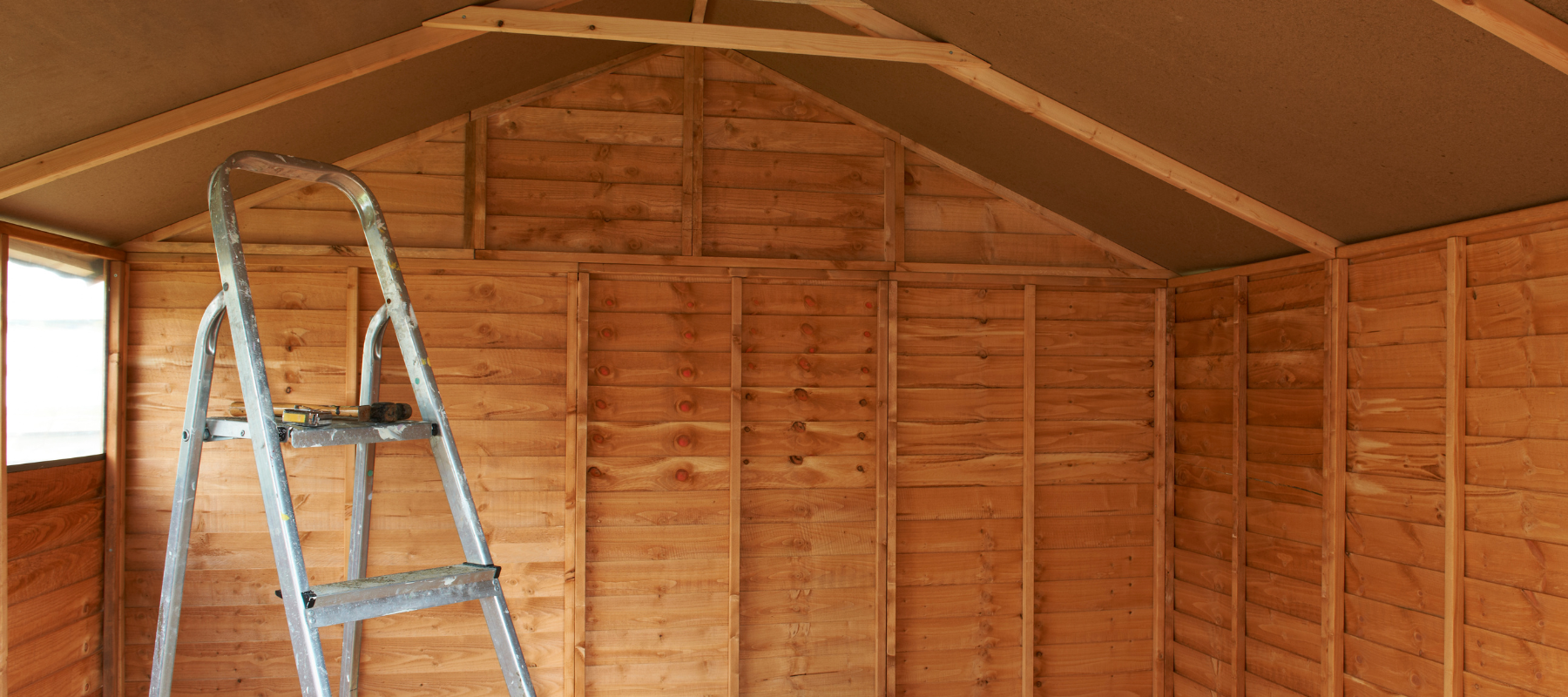 The interior of a shed with a ladder setup inside of it.